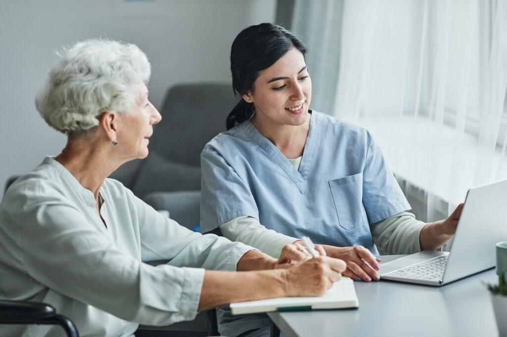 Female Nurse Assisting Senior Woman